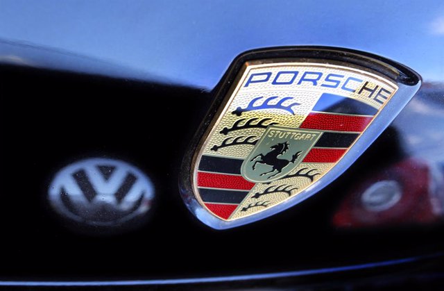 Archive - FILED - 05 juillet 2012, Bavière, Kaufbeuren : Vue générale d'un logo Porsche sur un véhicule à côté d'un reflet du logo Volkswagen. Le groupe Volkswagen semble aller de l'avant dans son projet d'introduire sa filiale de voitures de sport Porsche à la Bourse de New York.