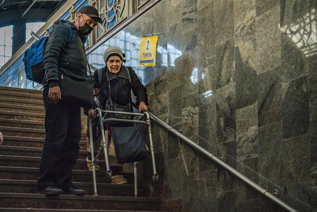 24 mars 2022, Lviv, Lviv, Ukraine : Un vieux réfugié ukrainien descend les escaliers avec de l'aide dans la gare principale de Lviv, échappant aux affrontements pendant la guerre de la Russie en Ukraine.,Image : 672894550, License : Droits gérés, Restrictions : 